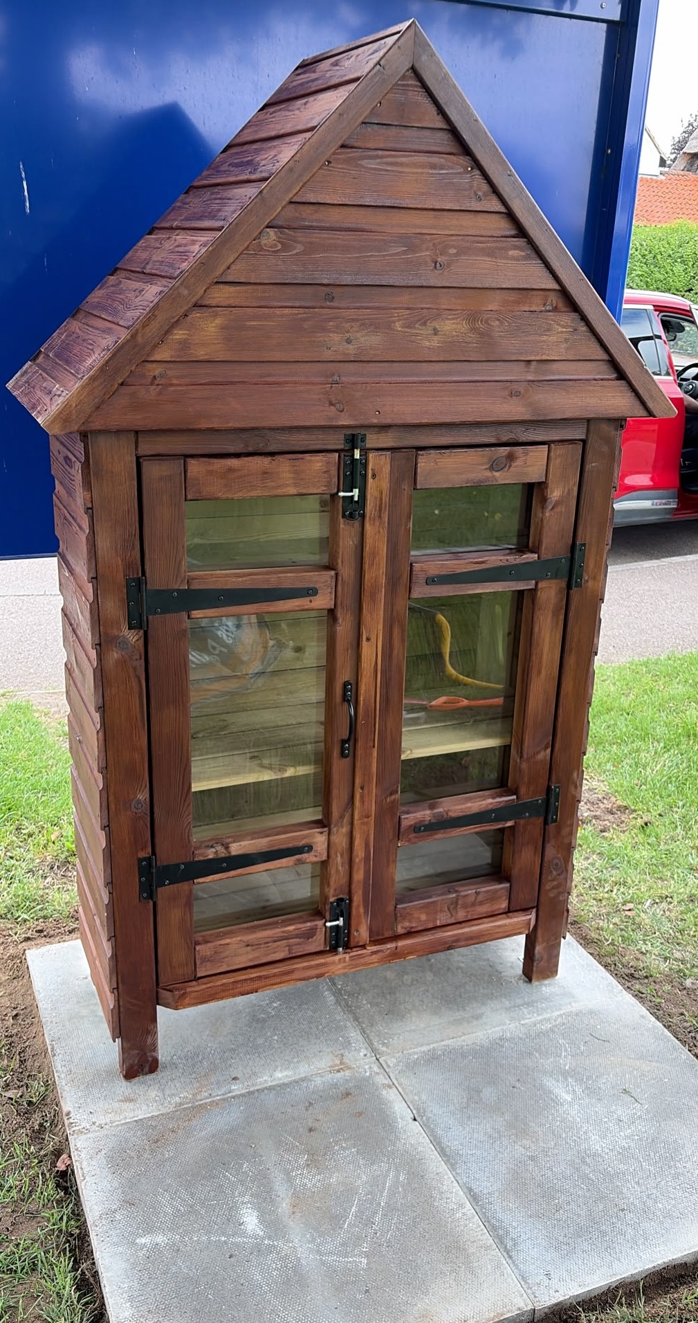 Classic wooden cabinet with glass screen to house books on paving slabs